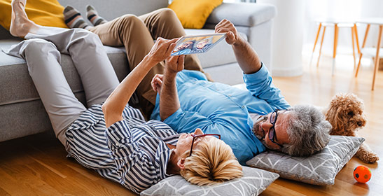 couple-taking-selfie-with-tablet-while-lying-on-floor