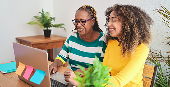 two-people-smiling-at-laptop